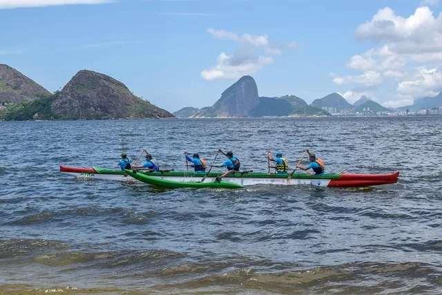 A team paddling an outrigger canoe in unison