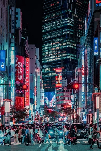 A busy city crossing at night with light trails